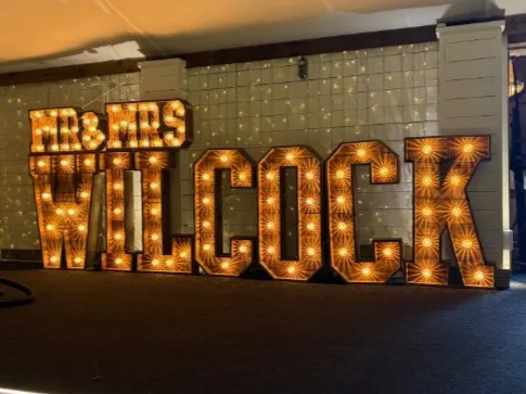 Rustic MR & MRS WILCOCK light up letters at a barn wedding