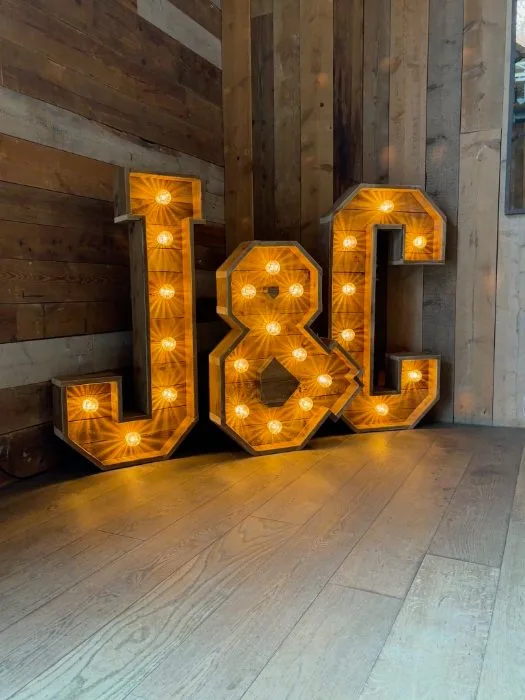 Rustic light up J & C initials on a wooden dance floor