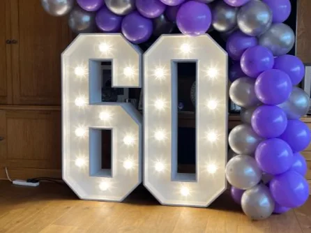 White light up number 60 with purple and silver balloons