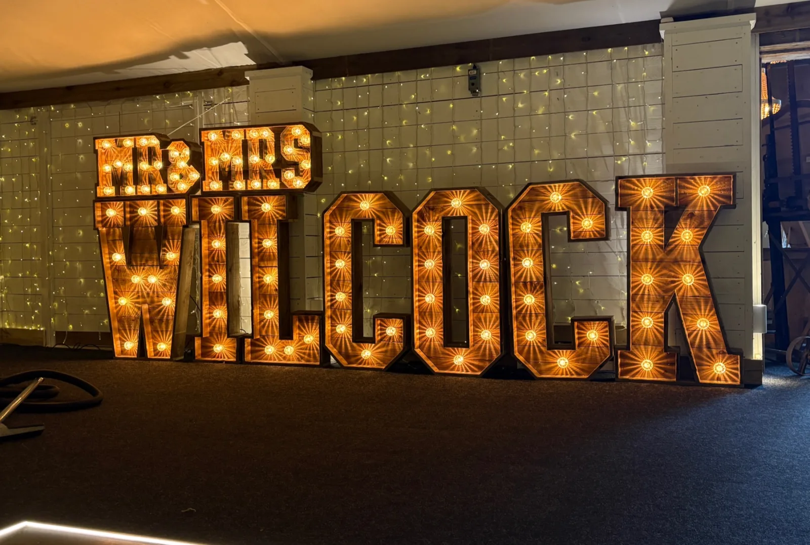 Rustic MR & MRS WILCOCK light up letters in a barn