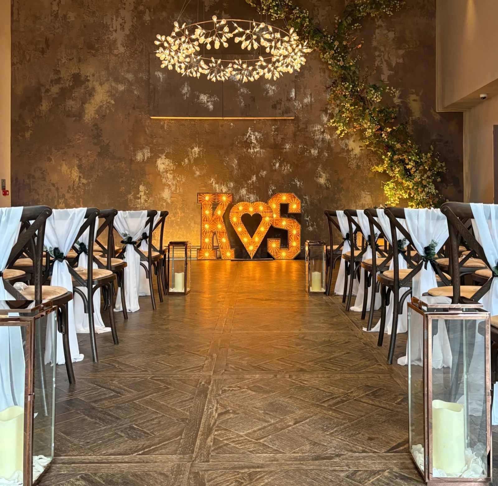 Rustic light up letters at the end of a wedding aisle