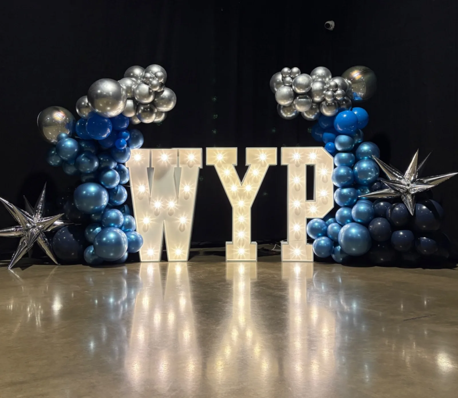 White light up letters spelling WYP with balloons