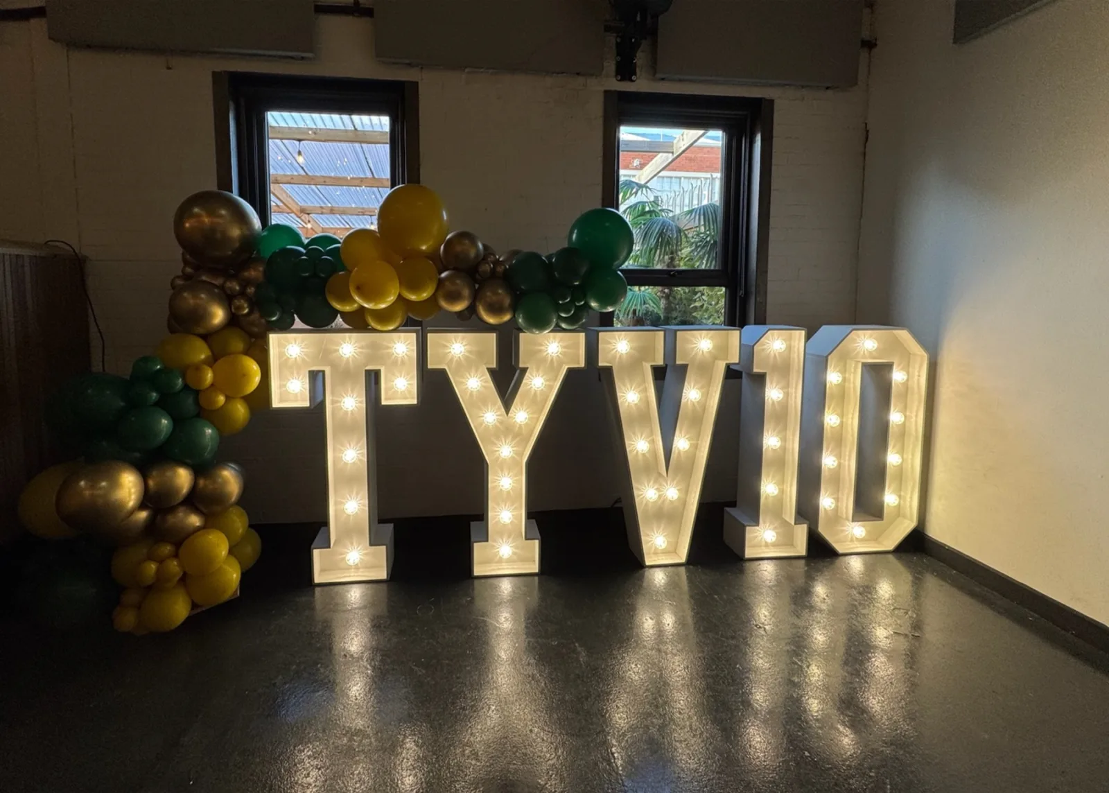 White light up letters spelling TYVIO at a corporate event