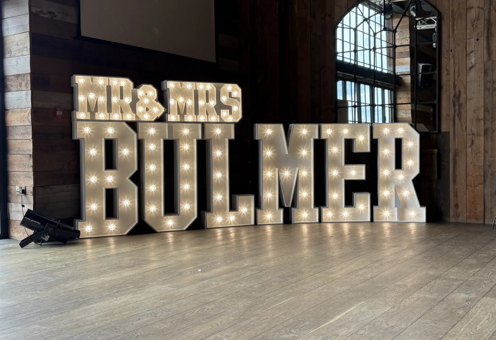 White MR & MRS BULMER light up letters in a barn